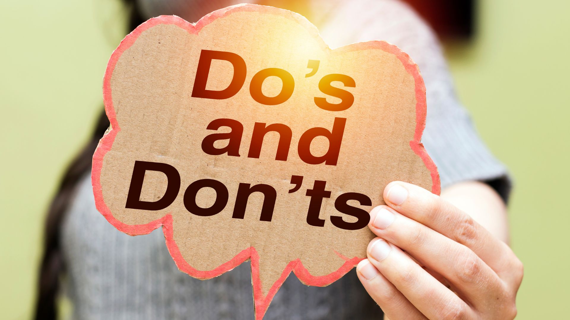 Hands Holding A Do's And Don'ts Sign