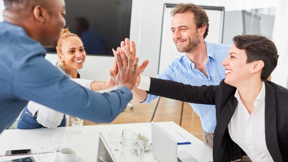 Professionals High Fiving In A Meeting