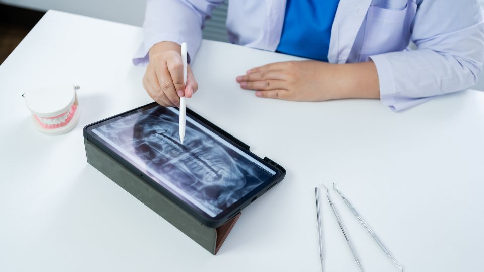 Dentist Examines X Ray Of A Jaw On A Tablet