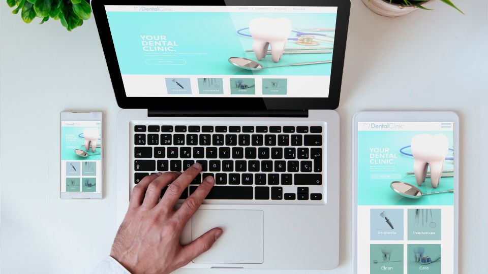 Person Exploring Dental Website On Multiple Devices