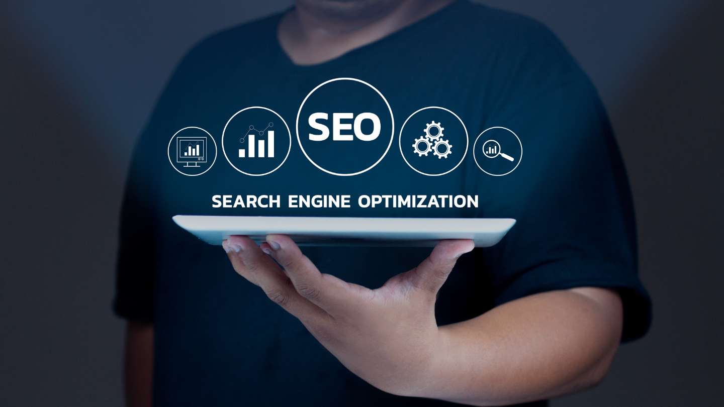 Person Holding A Tablet Displaying SEO Icons